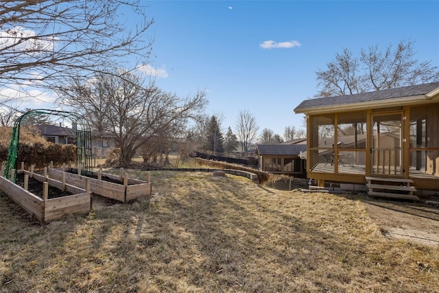 view of yard with a garden and a sunroom