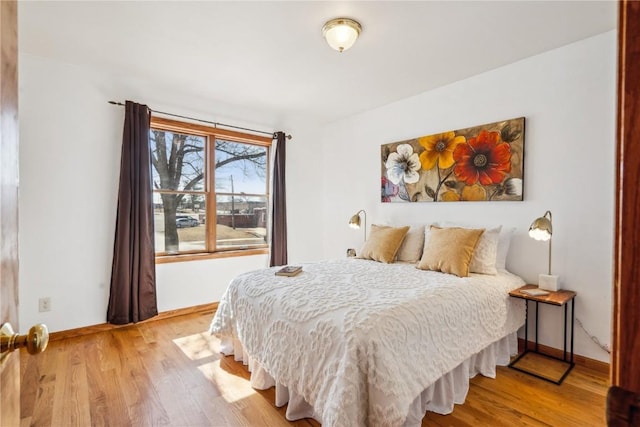 bedroom with light wood-style flooring and baseboards