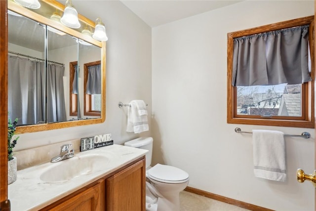 bathroom featuring vanity, toilet, a shower with curtain, and baseboards