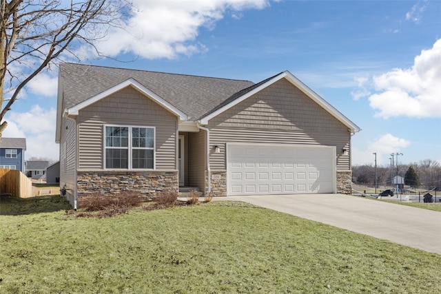 view of front of home featuring a front lawn, an attached garage, stone siding, and driveway