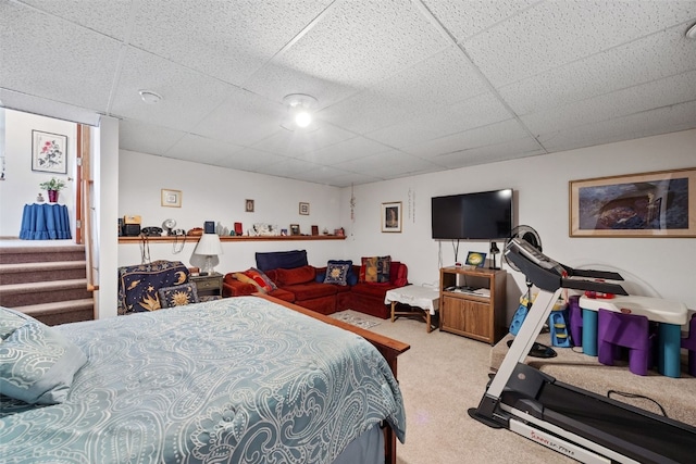 bedroom featuring a drop ceiling and carpet floors