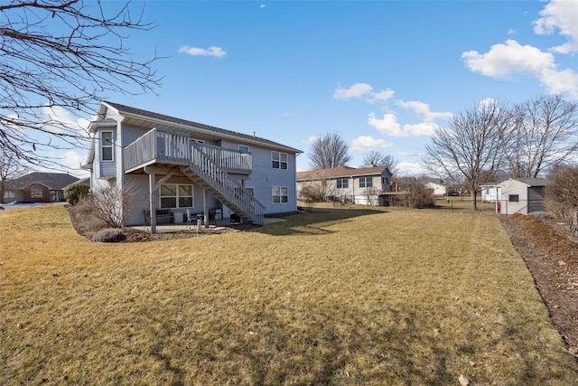 rear view of property with stairway, a wooden deck, and a yard