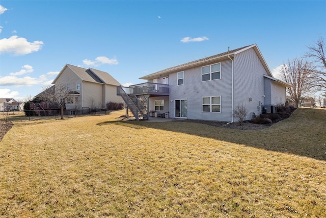 back of house featuring fence, a wooden deck, stairs, central AC, and a yard