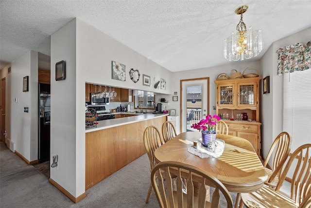 dining area with light carpet, a notable chandelier, a textured ceiling, and baseboards