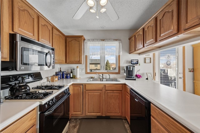 kitchen with a sink, stainless steel microwave, gas range oven, dishwasher, and ceiling fan