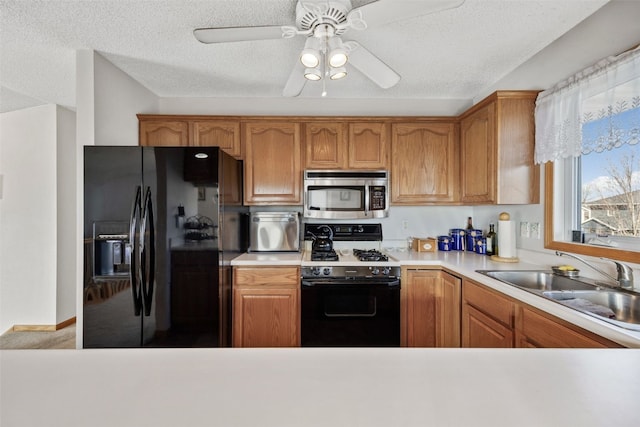 kitchen featuring a sink, stainless steel microwave, black fridge with ice dispenser, gas range, and ceiling fan