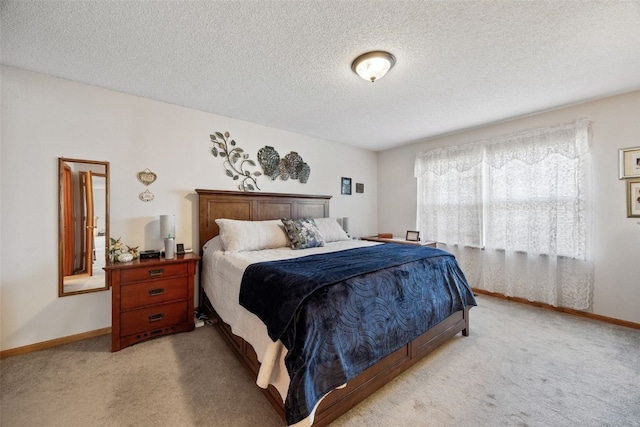 bedroom with a textured ceiling, baseboards, and light carpet