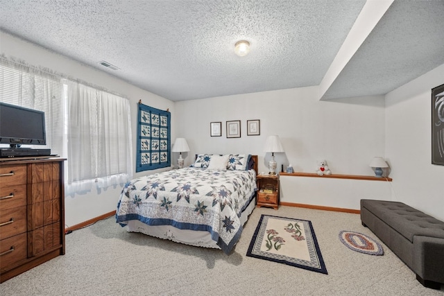 carpeted bedroom with baseboards, visible vents, and a textured ceiling