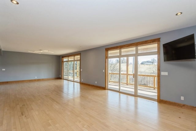 unfurnished living room featuring baseboards and light wood-style floors