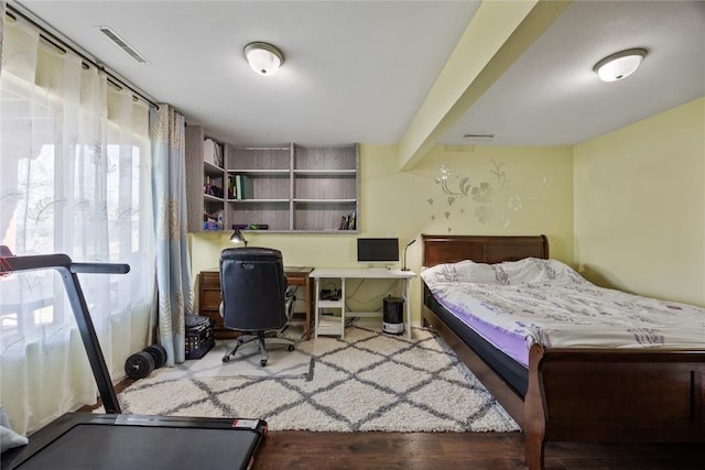 bedroom featuring beamed ceiling and visible vents