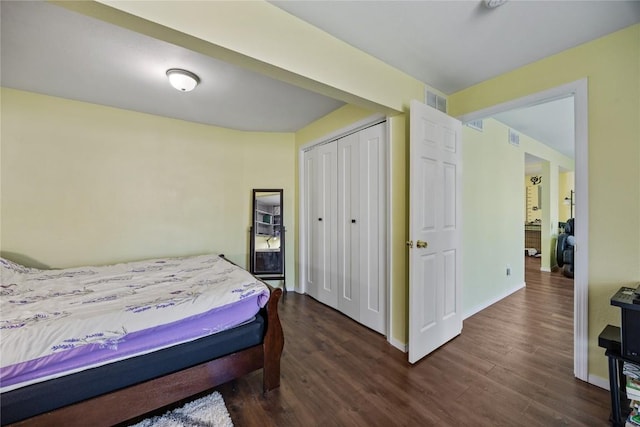 bedroom featuring a closet, visible vents, baseboards, and dark wood-style flooring