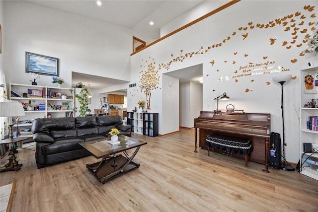 living room featuring baseboards, a high ceiling, and wood finished floors