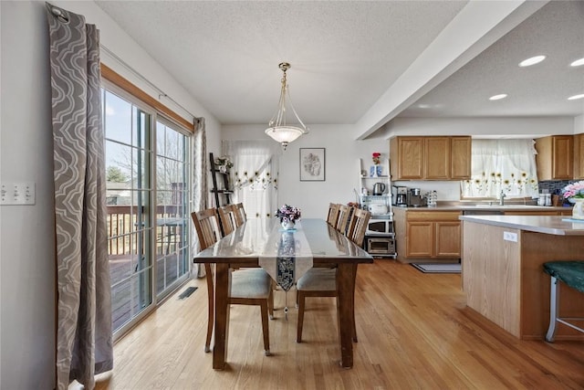 dining space with recessed lighting, visible vents, light wood-style flooring, and a textured ceiling