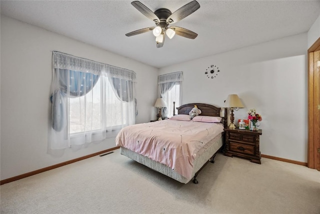 bedroom featuring visible vents, baseboards, carpet, and a textured ceiling