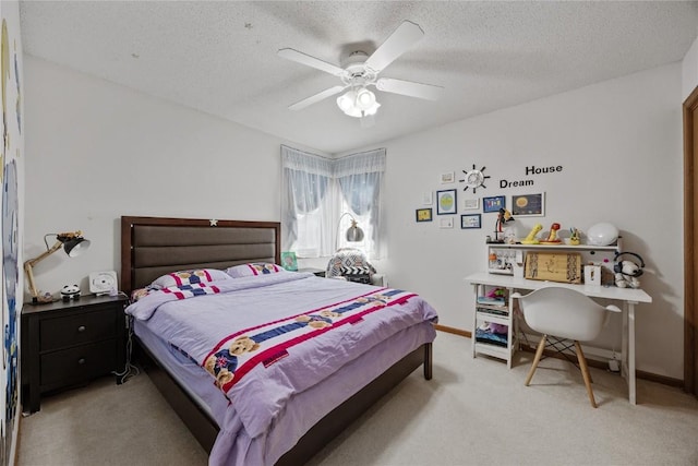 bedroom with baseboards, light carpet, a textured ceiling, and a ceiling fan