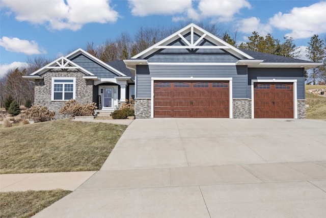 craftsman-style house with concrete driveway, an attached garage, stone siding, and a front yard