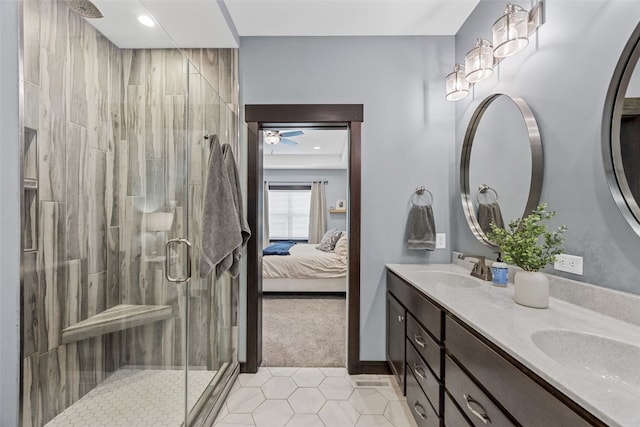 bathroom featuring double vanity, a shower stall, ensuite bathroom, and a sink