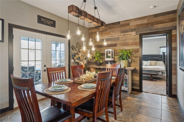 dining space with wooden walls and french doors