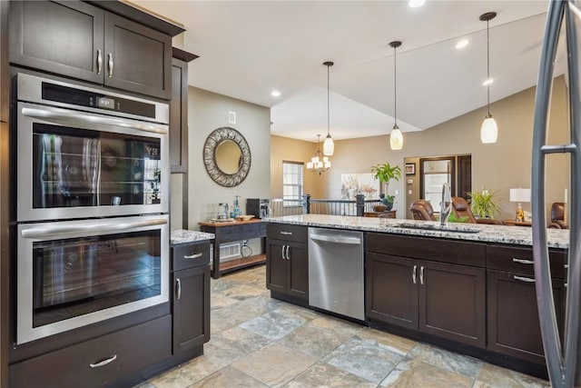 kitchen featuring light stone countertops, a sink, dark brown cabinetry, appliances with stainless steel finishes, and a chandelier