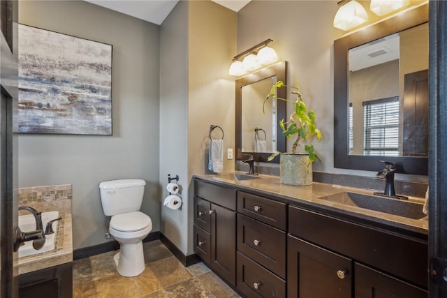 full bath featuring double vanity, toilet, baseboards, and a sink