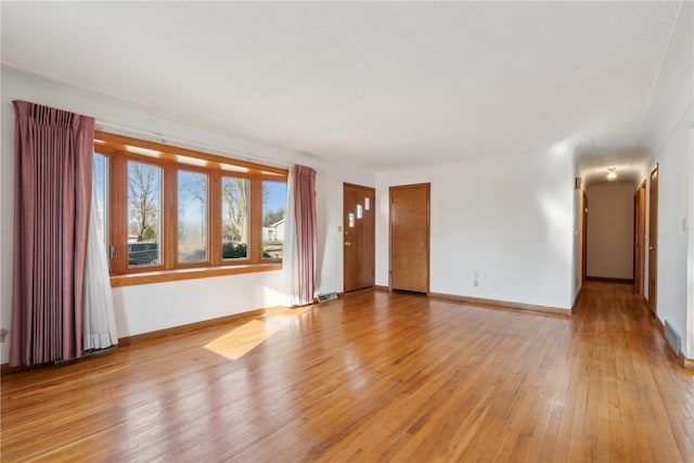 unfurnished living room featuring baseboards and light wood-style floors