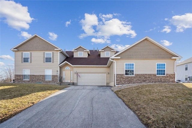 view of front of home featuring brick siding, a garage, a front lawn, and driveway