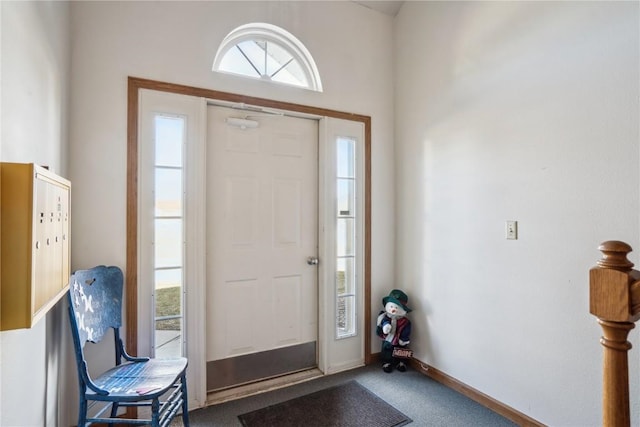 entryway with baseboards and carpet flooring