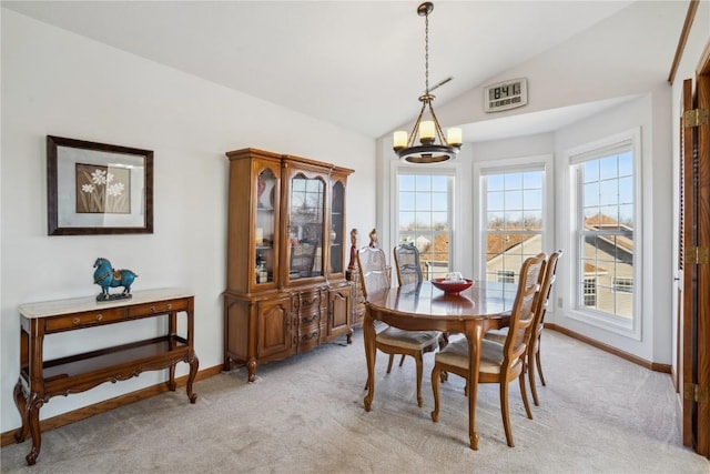 dining area featuring light carpet, an inviting chandelier, baseboards, and lofted ceiling