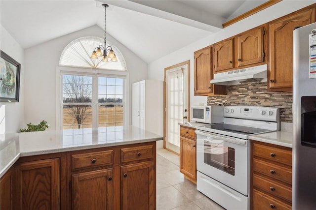 kitchen featuring tasteful backsplash, under cabinet range hood, light countertops, vaulted ceiling, and white appliances