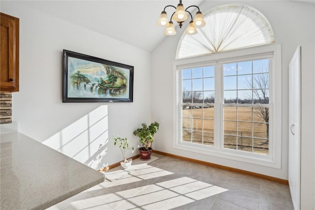 unfurnished dining area with baseboards, lofted ceiling, and a chandelier