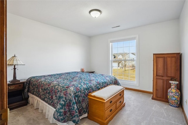 bedroom with baseboards, visible vents, and light carpet