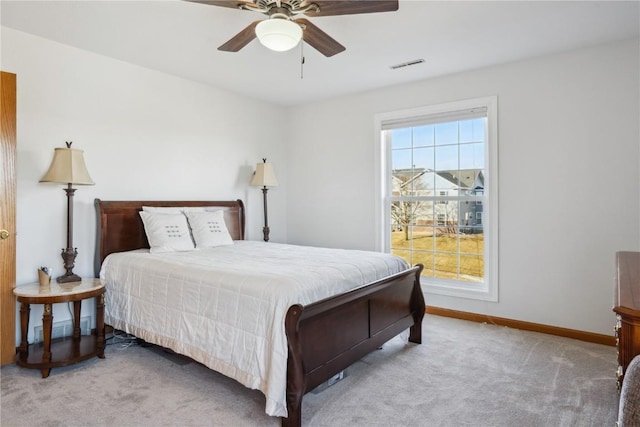 carpeted bedroom with visible vents, baseboards, and a ceiling fan