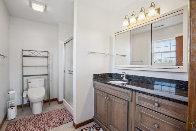 full bathroom with vanity, a shower stall, toilet, and baseboards