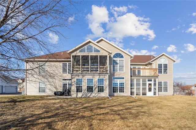 back of house with a lawn and a sunroom