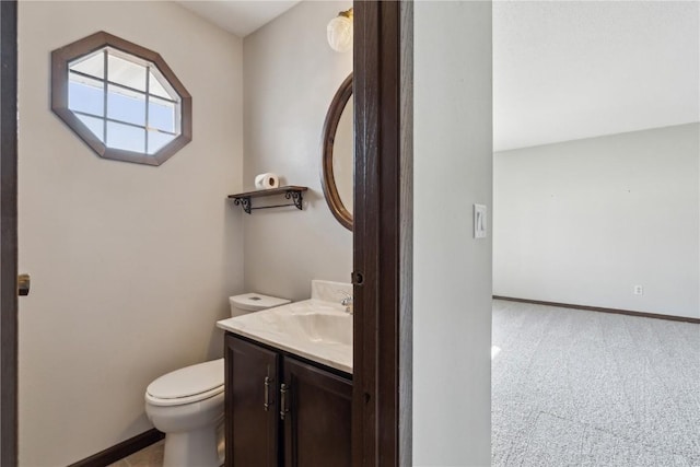 bathroom featuring baseboards, toilet, and vanity