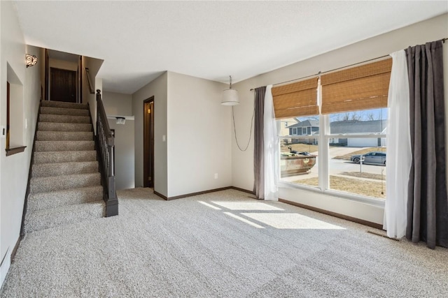 interior space with baseboards, stairs, and carpet