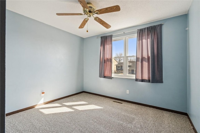 carpeted spare room with visible vents, baseboards, a textured ceiling, and ceiling fan