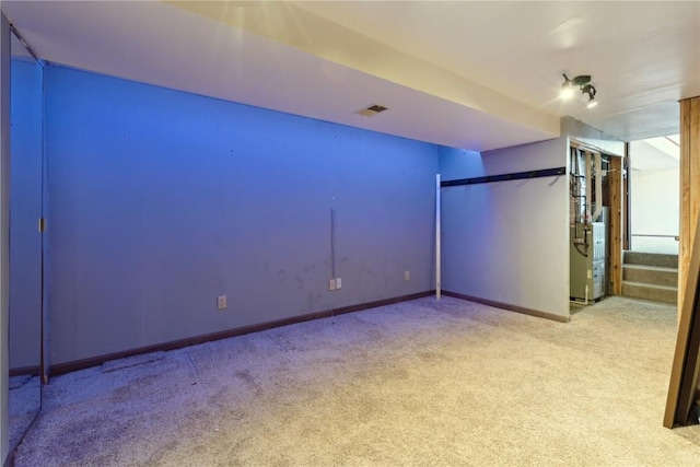 unfurnished room featuring visible vents, light carpet, baseboards, and stairs