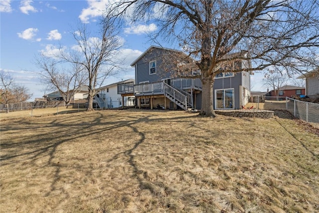 back of house with stairway, a fenced backyard, a yard, and a wooden deck