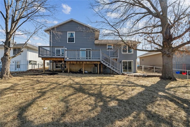 rear view of property with a yard, a deck, stairs, and fence