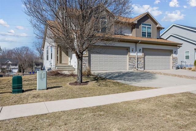 view of front of house featuring stone siding, driveway, and board and batten siding