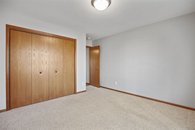 unfurnished bedroom featuring a closet, carpet floors, and baseboards