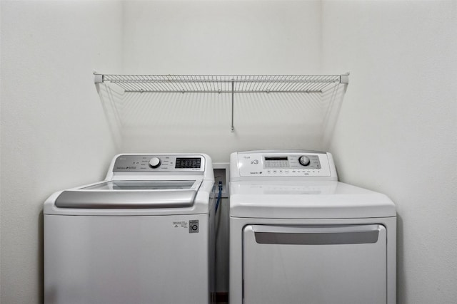 clothes washing area featuring washer and dryer and laundry area