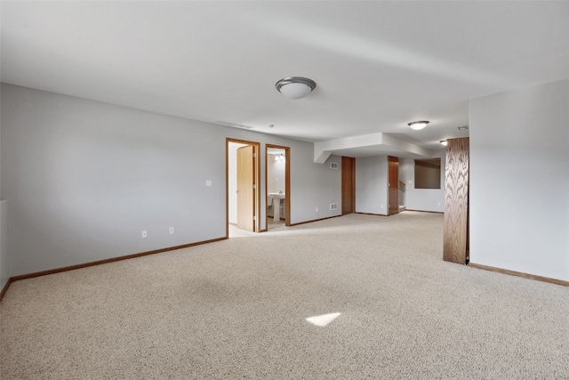 empty room featuring light colored carpet and baseboards