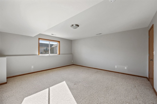 carpeted spare room with visible vents and baseboards