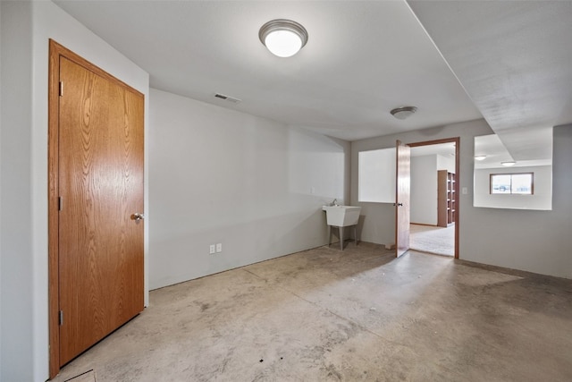 basement featuring visible vents and a sink