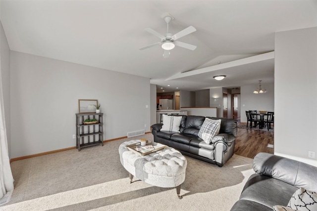 living room with visible vents, ceiling fan with notable chandelier, baseboards, and lofted ceiling