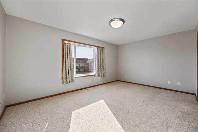 carpeted empty room with baseboards