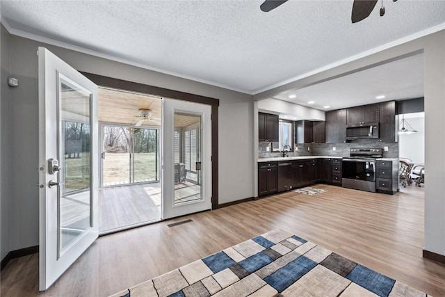 2261 Creekside Rd, Springville, IA 52336 - kitchen featuring stainless steel appliances, ceiling fan, light countertops, a textured ceiling, and backsplash