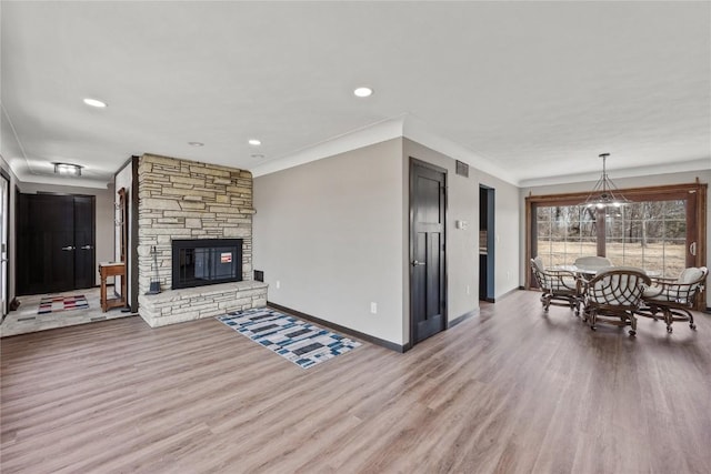 living area featuring baseboards, ornamental molding, recessed lighting, a fireplace, and wood finished floors